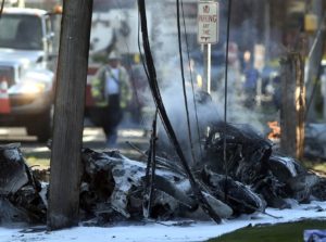 Chiếc phi cơ bị bốc cháy sau khi bị nạn. Photo Courtesy: Michaud / Journal Inquirer via AP