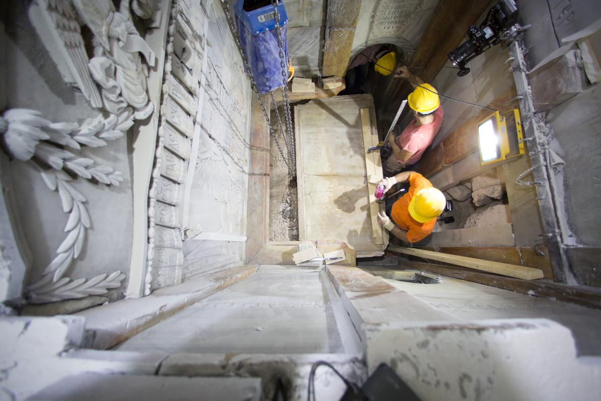 Các công nhân kéo tấm đá cẩm thạch che ngôi mộ, hé lộ rất nhiều vật liệu bên trong